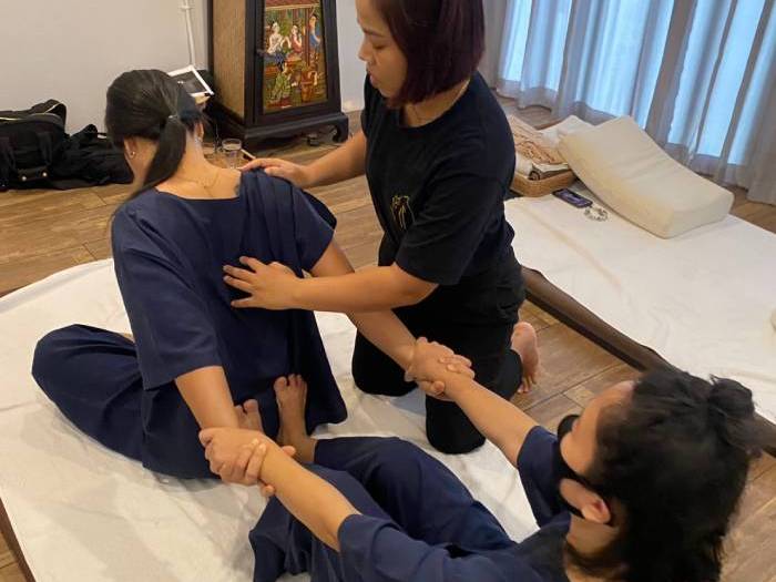Instructor correction during Thai massage training
