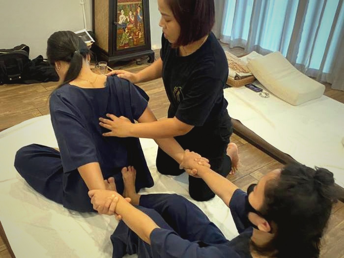 Instructor correction during Thai massage training