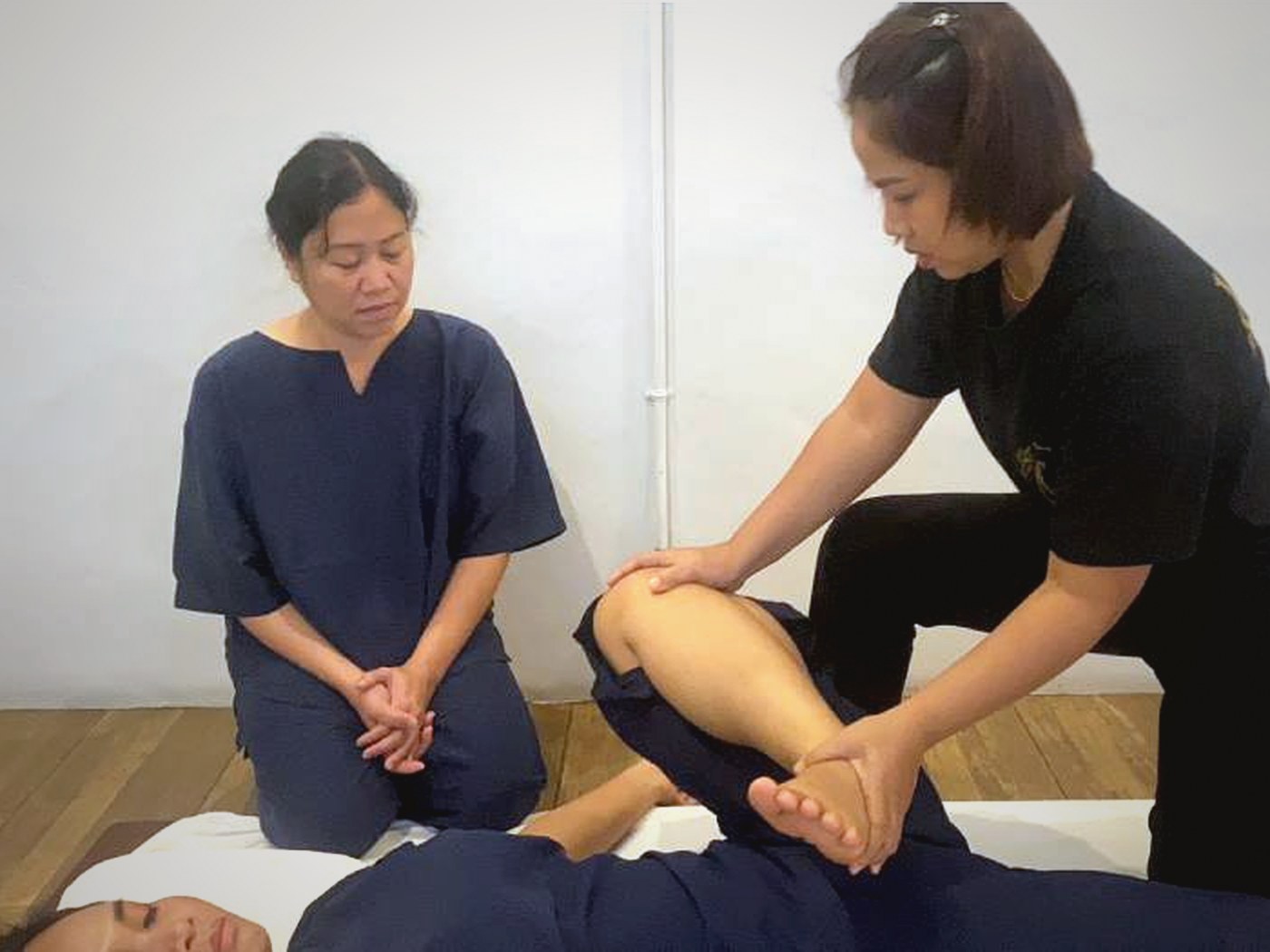 Thai massage training on a mat in Bangkok